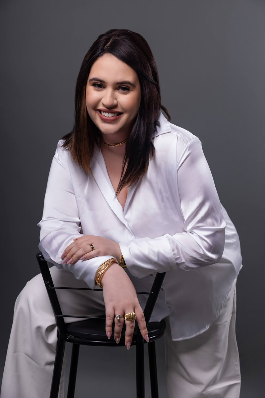 Dra. Isabela Bueno apoiada em uma cadeira